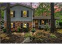 Charming home exterior at dusk, featuring a cozy front porch and inviting, landscaped front yard at 1292 Marcelle Heights Nw Pl, Norcross, GA 30093