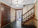 Elegant home foyer with black tile flooring, staircase, and detailed wood trim around the doorways at 2340 Castleridge Ct, Tucker, GA 30084