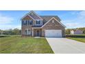 New two story brick home featuring a two car garage, well manicured lawn, and classic architectural design at 115 Felicity Pike, Locust Grove, GA 30248