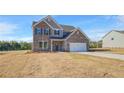 Two story brick home featuring a two car garage and classic architectural design on a large lot at 115 Felicity Pike, Locust Grove, GA 30248