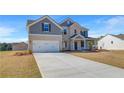 Stunning two-story home with brick accents, gray siding, a pristine lawn, and an expansive driveway at 123 Felicity Pike, Locust Grove, GA 30248