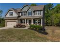 Beautiful two-story home with a welcoming front porch, attached garage, and a well-maintained lawn with landscaping at 19 Four Feathers Ne Ln, Rydal, GA 30171