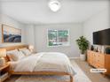 Comfortable main bedroom featuring a queen bed, dresser, TV and sunlit window at 1704 Golf Link Dr, Stone Mountain, GA 30088