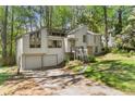 Charming two-story house with a two-car garage nestled among lush trees in a beautiful landscape at 3923 Lookout Point Dr, Marietta, GA 30066