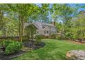 Lush backyard with manicured lawn, mature trees, a wooden fence, and a charming deck off the house at 5251 Amberbrook Ct, Marietta, GA 30068