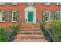 Inviting brick steps leading to a bright green front door, framed by symmetrical landscaping and black shutters at 5251 Amberbrook Ct, Marietta, GA 30068