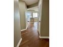 Hallway with hardwood floors leading to kitchen with white cabinets and island at 795 Hammond Dr # 1908, Atlanta, GA 30328