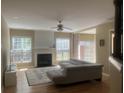 Bright living room showcasing a cozy fireplace, hardwood floors, large windows, and a comfortable sectional sofa at 1491 Bellsmith Dr, Alpharetta, GA 30076