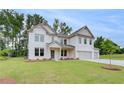 Beautiful brick home with a welcoming front porch, three-car garage, and a meticulously landscaped lawn at 174 Haverling Pass, Hampton, GA 30252
