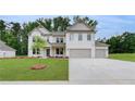 Charming white brick home with a three-car garage and a lush green lawn, ideal for suburban living at 174 Haverling Pass, Hampton, GA 30252