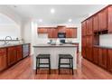 Open kitchen features dark cabinets, an island with bar seating and stainless-steel appliances, creating a functional and stylish space at 282 Autry Mill Ln, Suwanee, GA 30024
