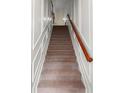 Elegant staircase featuring carpeted steps, white trim and an appealing wooden handrail, inviting one to explore the upper floors at 282 Autry Mill Ln, Suwanee, GA 30024