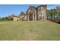 Inviting two-story home with brick accents, a manicured lawn, and mature trees at 3798 Spring Place Ct, Loganville, GA 30052
