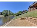Tranquil backyard view with waterfront access, patio, retaining wall, and mature trees at 870 Longstone Lndg, Alpharetta, GA 30022