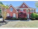 Charming brick home featuring symmetrical design, lush landscaping, and inviting entrance at 870 Longstone Lndg, Alpharetta, GA 30022