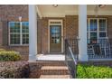 Welcoming front porch with a brick entryway and white pillars, enhancing curb appeal at 1060 Crescent Ridge Dr, Buford, GA 30518