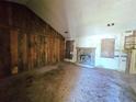 Spacious living room featuring a fireplace, exposed studs, and wood paneling at 35 Belmont Way, Covington, GA 30016