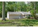 Quaint single-story home with a well-maintained lawn, a covered porch, and a detached garage at 2374 Rolling Acres Sw Dr, Conyers, GA 30094
