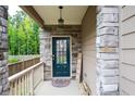 Stylish front door with stone accents and decorative lighting, adding character to the home's facade at 5638 Berney Cir, Powder Springs, GA 30127