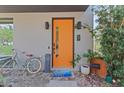 A close-up of the home's bright orange front door with modern hardware and charming welcome mat at 127 Ravenhurst Dr, Fayetteville, GA 30214