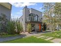 Modern two-story home with gray brick, balcony, vibrant orange door, and a landscaped front yard at 127 Ravenhurst Ln, Fayetteville, GA 30214