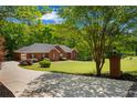 An estate brick home sits on a manicured large lot with mature trees at 215 The Farm Rd, Mcdonough, GA 30252