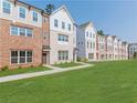 Row of townhomes featuring brick and vinyl siding, green lawns, and inviting curb appeal at 3409 Catalan Aly, Decatur, GA 30032