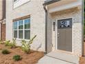 Close up of a front door with modern design and brick and wood trim, set in a landscaped yard at 3409 Catalan Aly, Decatur, GA 30032