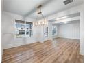 Formal dining area features wood floors, wainscoting, modern chandelier, and bright windows at 4201 Hosch Reserve Dr, Buford, GA 30519