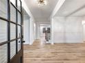Elegant foyer showcasing wood floors, wainscoting, and natural light from a large glass door at 4201 Hosch Reserve Dr, Buford, GA 30519