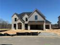 Charming gray brick, two-story home featuring an attached two-car garage and a traditional design at 4201 Hosch Reserve Drive Park, Buford, GA 30519
