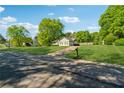 Exterior view of a charming home with a spacious front yard and a long driveway on a tree lined street at 705 Trickum Valley Dr, Woodstock, GA 30188