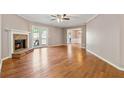 Spacious living room featuring a brick fireplace, ceiling fan and hardwood floors with ample natural light at 705 Trickum Valley Dr, Woodstock, GA 30188