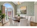 Bright dining room with a large arched window, chandelier, and seating for six people at 1031 Ludwick Way, Lawrenceville, GA 30046