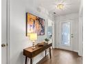 A welcoming foyer with wood floors, console table and lamp, and a decorative glass front door at 1031 Ludwick Way, Lawrenceville, GA 30046