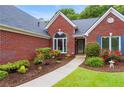 Charming brick home featuring a front entrance with a manicured flower bed at 1031 Ludwick Way, Lawrenceville, GA 30046