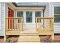 A welcoming front porch with fresh flowers and a bright red door invites you into this beautiful home at 128 Partridge Rdg, Woodstock, GA 30188