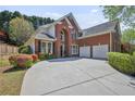 Traditional two-story brick home featuring a spacious driveway and manicured landscaping at 4232 Millside Se Walk, Smyrna, GA 30080
