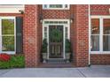 Close-up of a brick home's front door with a wreath and potted greenery at 4232 Millside Se Walk, Smyrna, GA 30080
