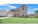 Beautiful two-story brick home with a covered front porch and lush green lawn, reflecting classic elegance at 124 Aj Welch Jr Way, Mcdonough, GA 30252