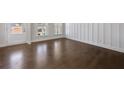 Elegant living room features rich hardwood floors, wainscoting detail, and sunlit windows, creating a welcoming space at 124 Aj Welch Jr Way, Mcdonough, GA 30252