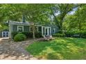 Quaint single-story house featuring mature trees, a well-manicured lawn and a cozy, inviting curb appeal at 1248 Conway Rd, Decatur, GA 30030
