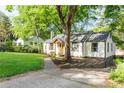 Well-maintained home features a neatly manicured lawn and mature trees offering shade at 1611 Belmont Sw Ave, Atlanta, GA 30310
