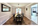 Elegant dining room boasts wood-look flooring, stylish furnishings, and ample natural light for enjoyable meals at 5223 Hollyfield Dr, Stone Mountain, GA 30088