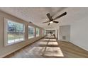 Spacious living room with a ceiling fan, large windows, and new flooring at 1206 Kern Cv, Mcdonough, GA 30253