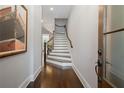 Bright entryway features hardwood floors, staircase with white risers and dark wood trim, and large painting at 126 Abbington River Ln, Atlanta, GA 30339