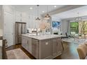 Open concept kitchen with stainless steel appliances, gray island, white cabinetry, and adjacent living space at 126 Abbington River Ln, Atlanta, GA 30339