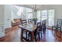 Elegant dining room with hardwood floors, large windows, staircase, and a table set for a meal at 2175 Eagle Trce, Cumming, GA 30040