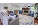 Cozy living room featuring a fireplace, large rug, comfortable seating, and views of the surrounding landscape at 2175 Eagle Trce, Cumming, GA 30040