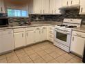 Kitchen with white cabinets, tile backsplash, and white appliances at 3082 Revere Ct, Atlanta, GA 30340